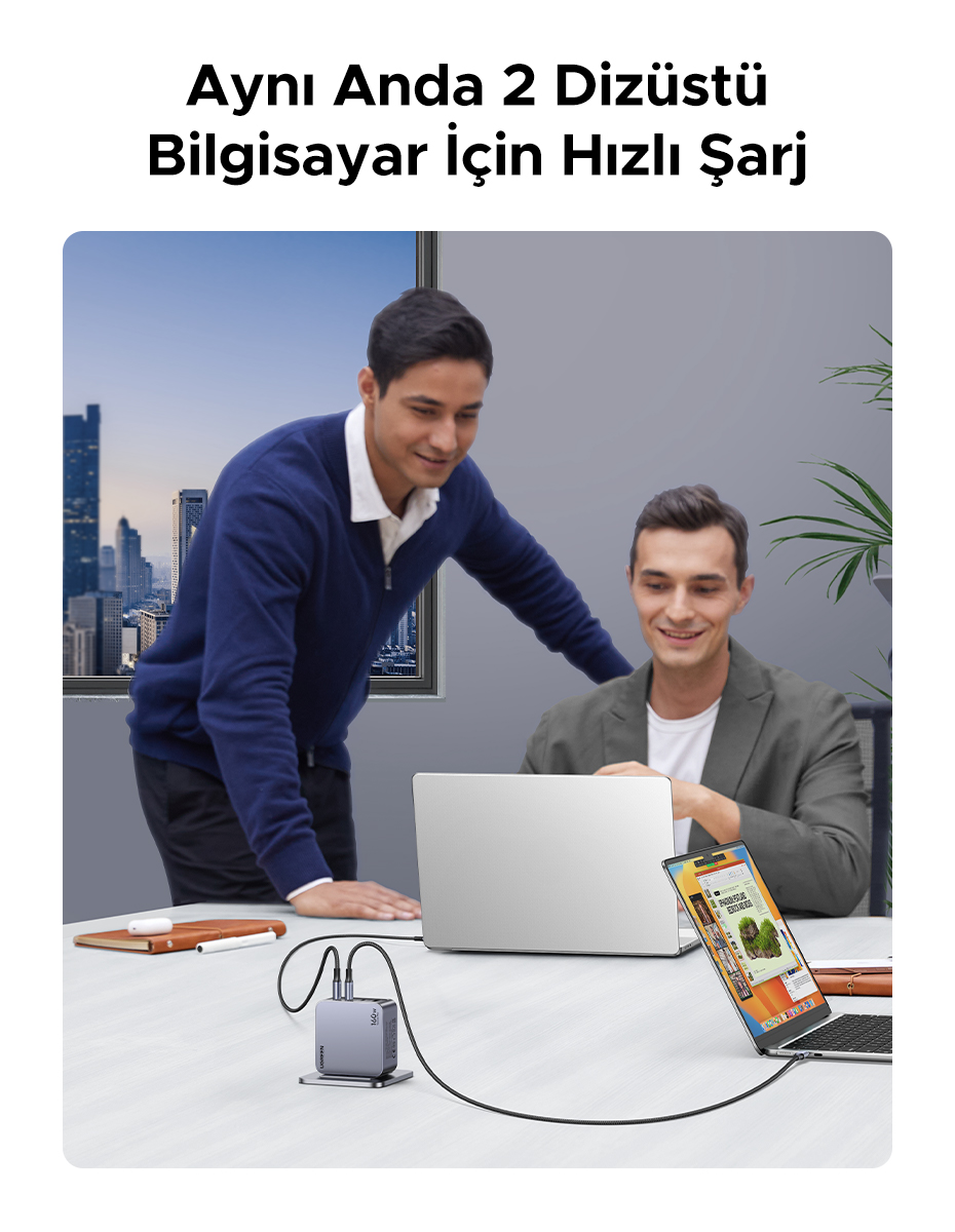 İki adam, bir dizüstü bilgisayar ve tablet ile birlikte çalışıyor ve çok portlu bir şarj cihazıyla şarj ediyor.