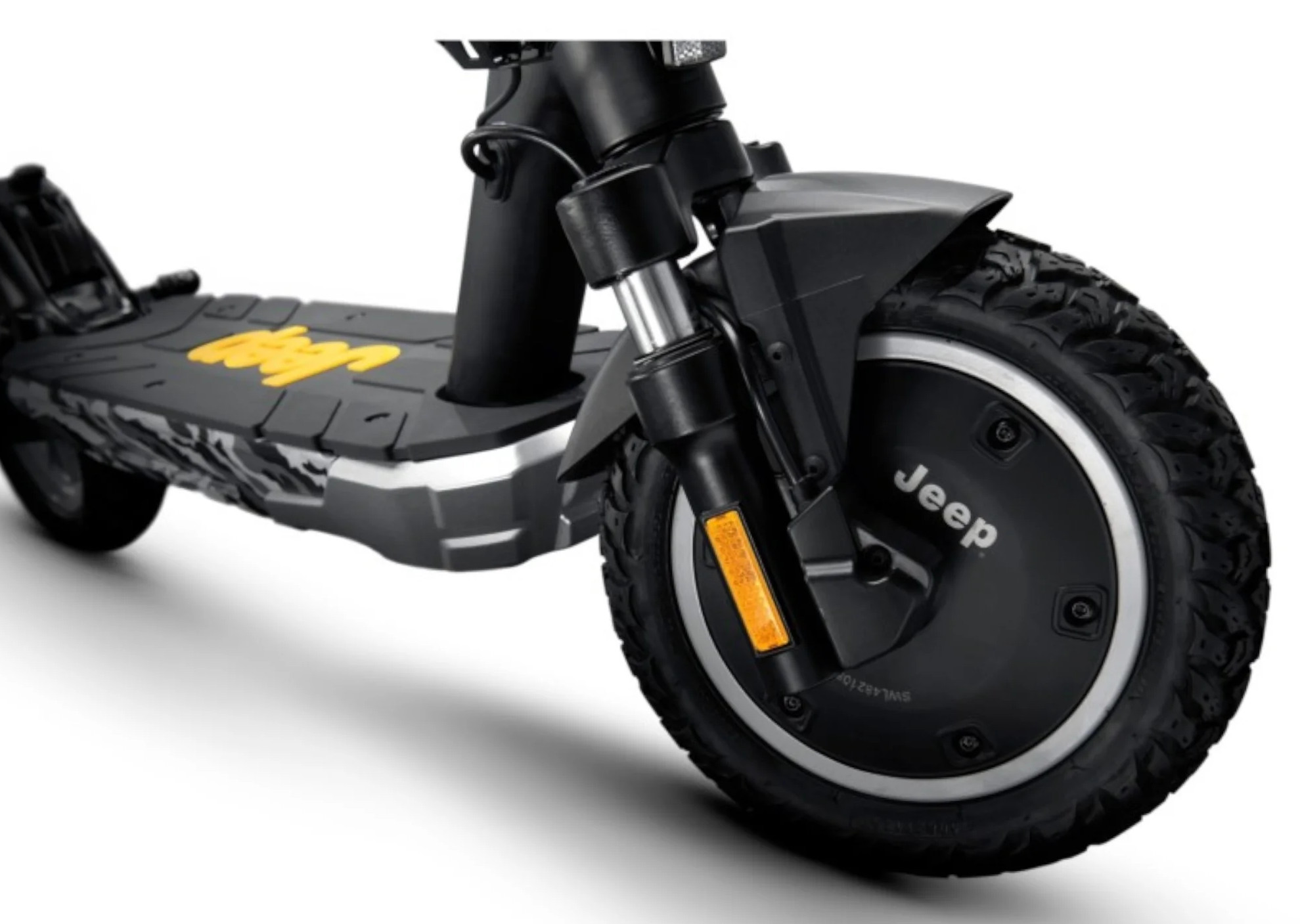 Zbliżenie przedniego koła skutera Jeep. Koło jest czarne ze srebrną obręczą i logo Jeep.