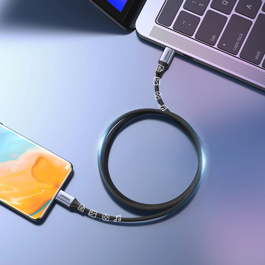 Bir telefon, siyah bir kabloyla bir dizüstü bilgisayara bağlı.