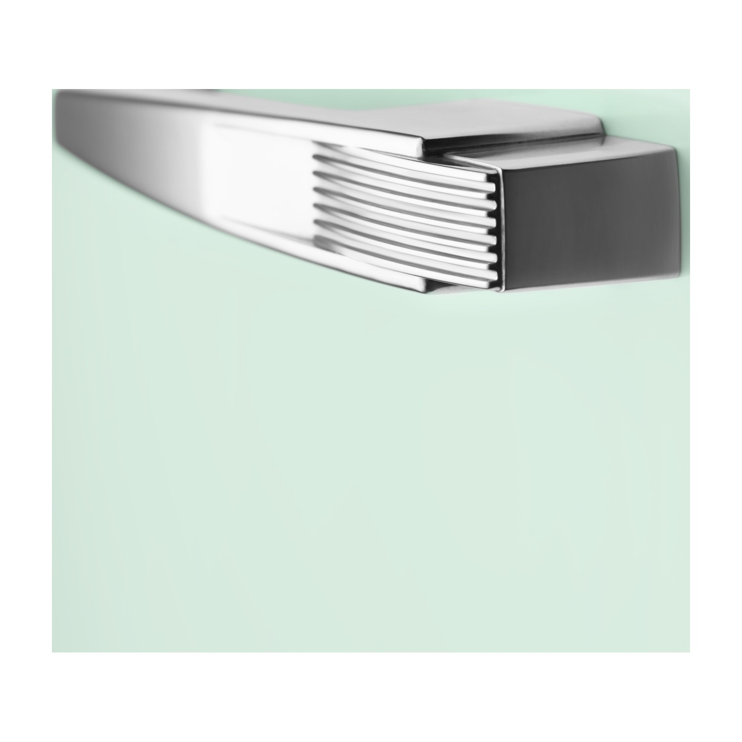Primo piano della maniglia di un frigorifero SMEG verde chiaro. Maniglia cromata con design a coste.