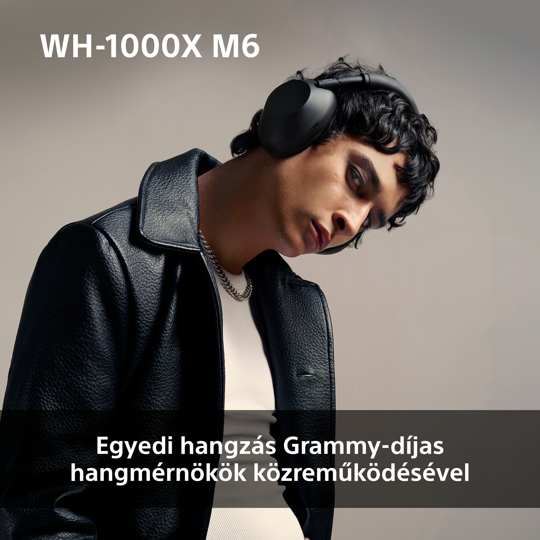 Férfi fekete fejhallgatóval, fekete dzsekiben. Szöveg: Egyedi hangzás Grammy-díjas hangmérnökök közreműködésével.