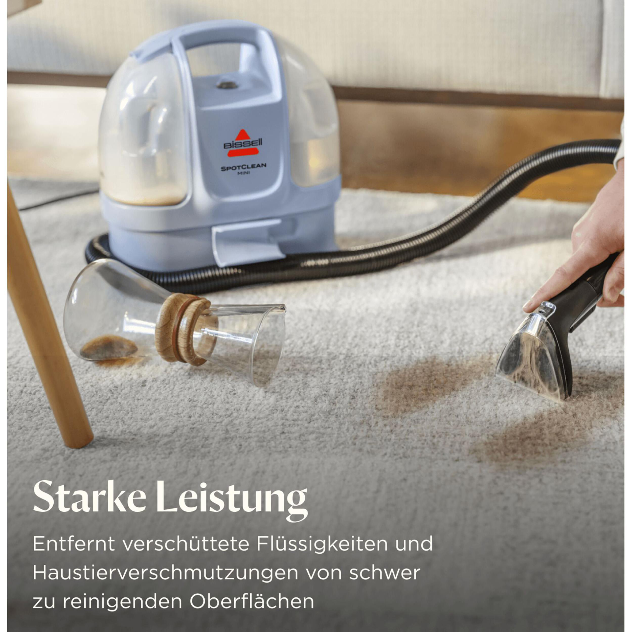 Eine Frau trägt einen tragbaren Reiniger in einem Wohnzimmer.