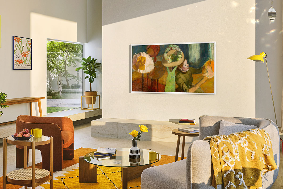 Soggiorno con TV che mostra un'opera d'arte. Arredamento include divano, poltrona, tappeto e tavolino.