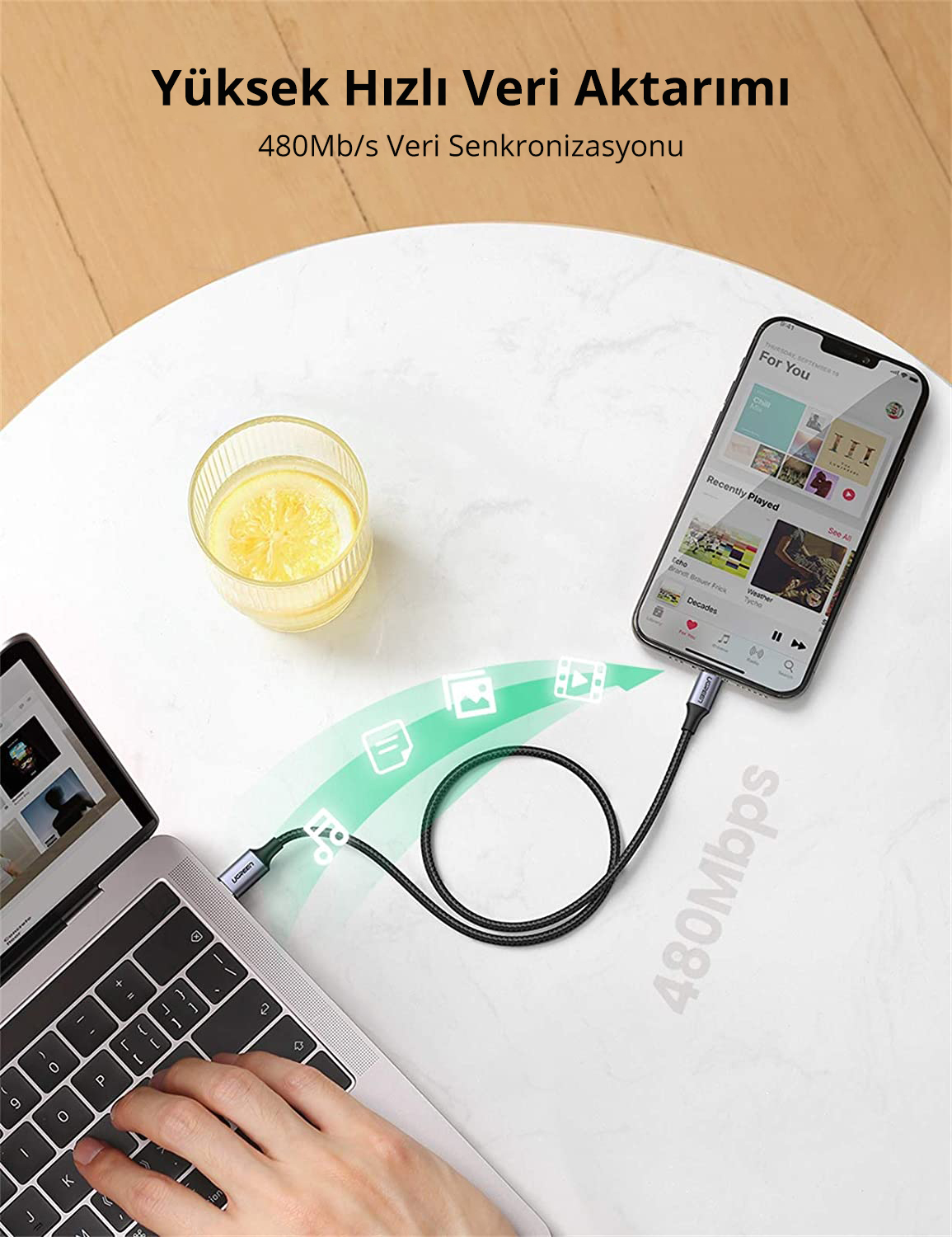 Bir UGREEN kablosuyla bağlı bir telefon ve dizüstü bilgisayar. Telefonda bir müzik uygulaması görüntüleniyor.