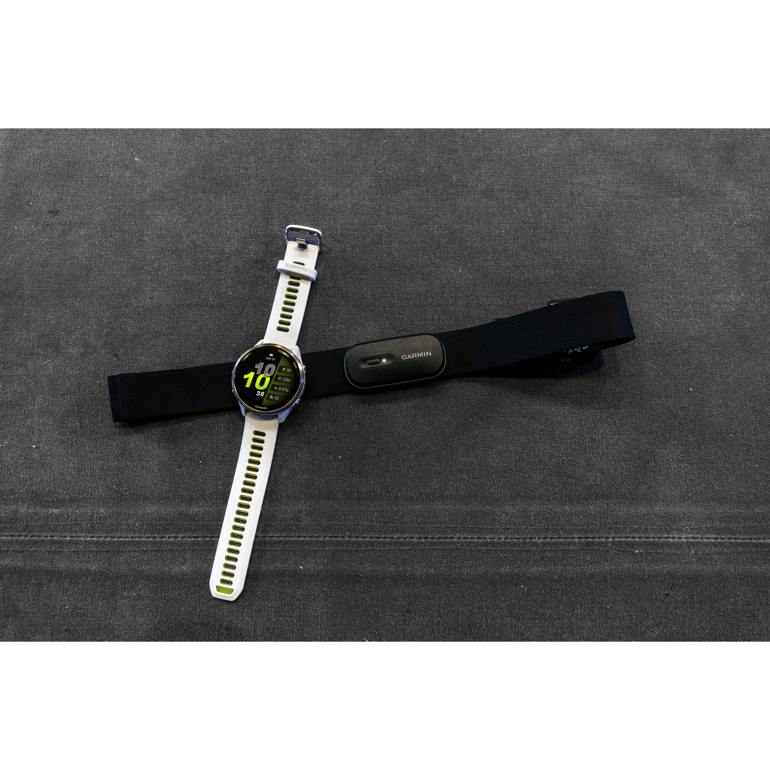 Garmin horloge en hartslagmeter op een grijze ondergrond. Het horloge toont gegevens.