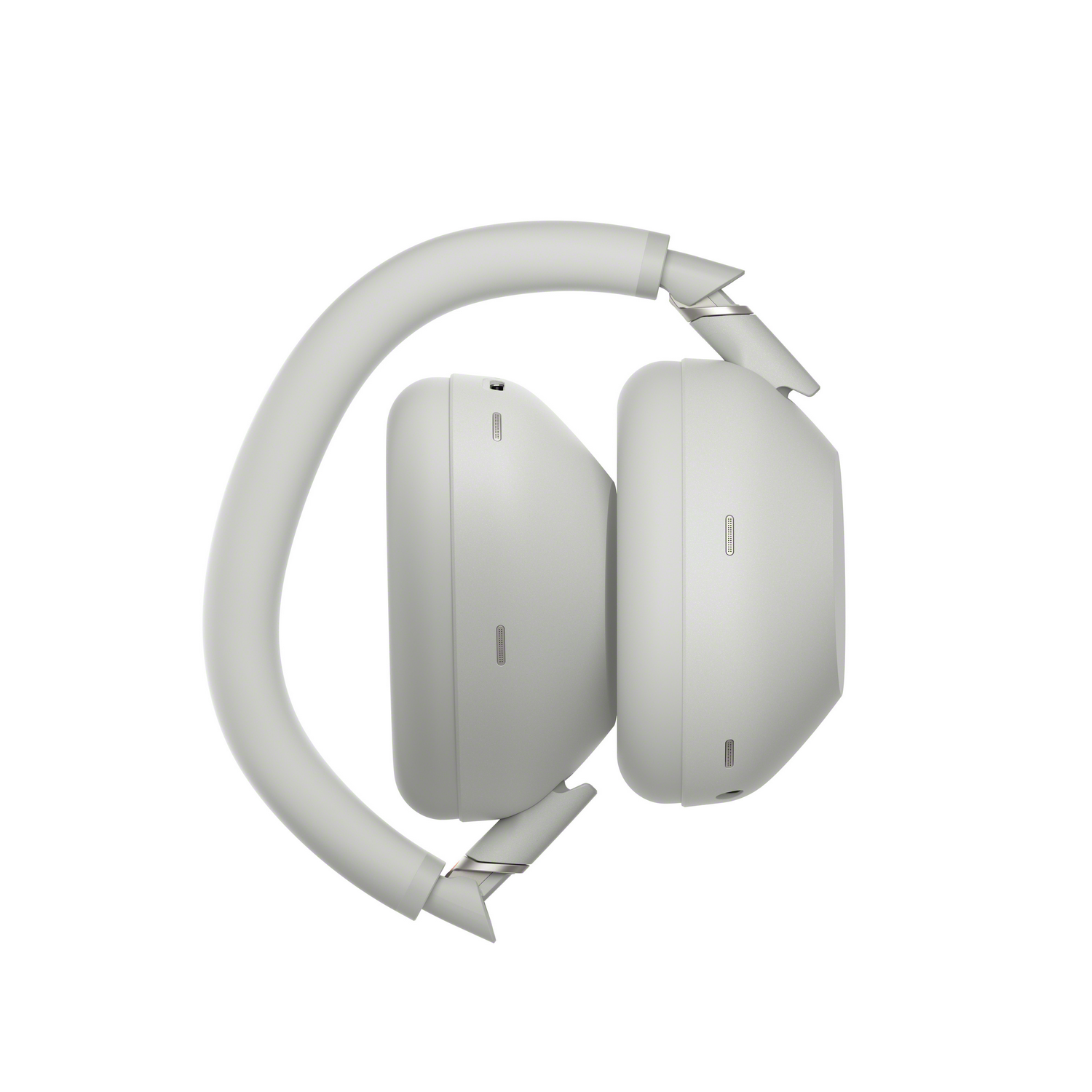 Auriculares Sony grises plegados. Vista lateral con copas y diadema. Fondo blanco.