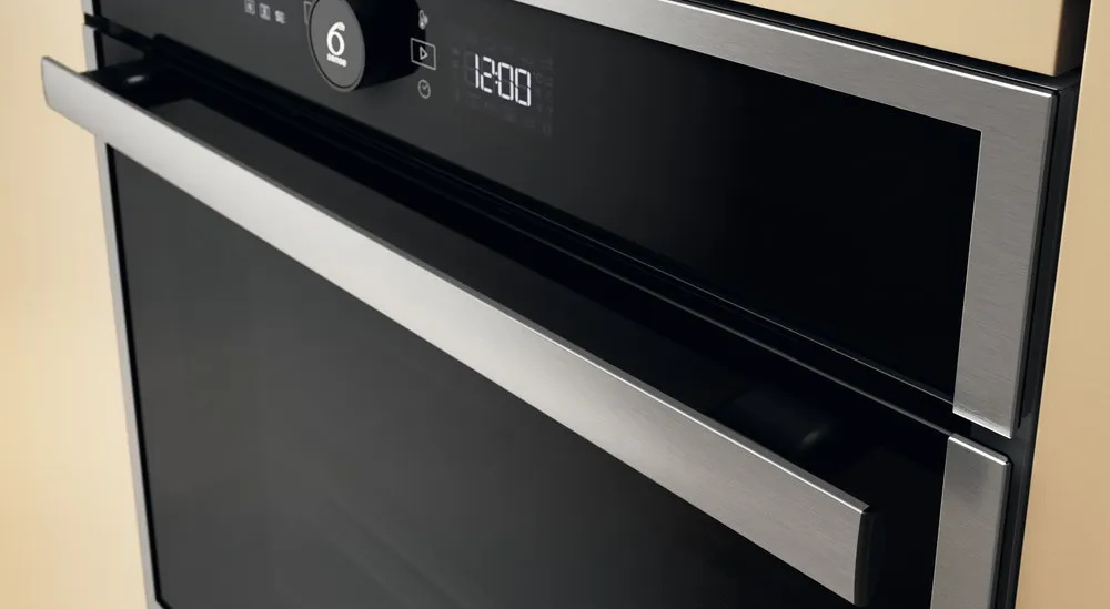 Zbliżenie piekarnika z uchwytem ze stali nierdzewnej i panelem sterowania, wyświetlającym godzinę.
