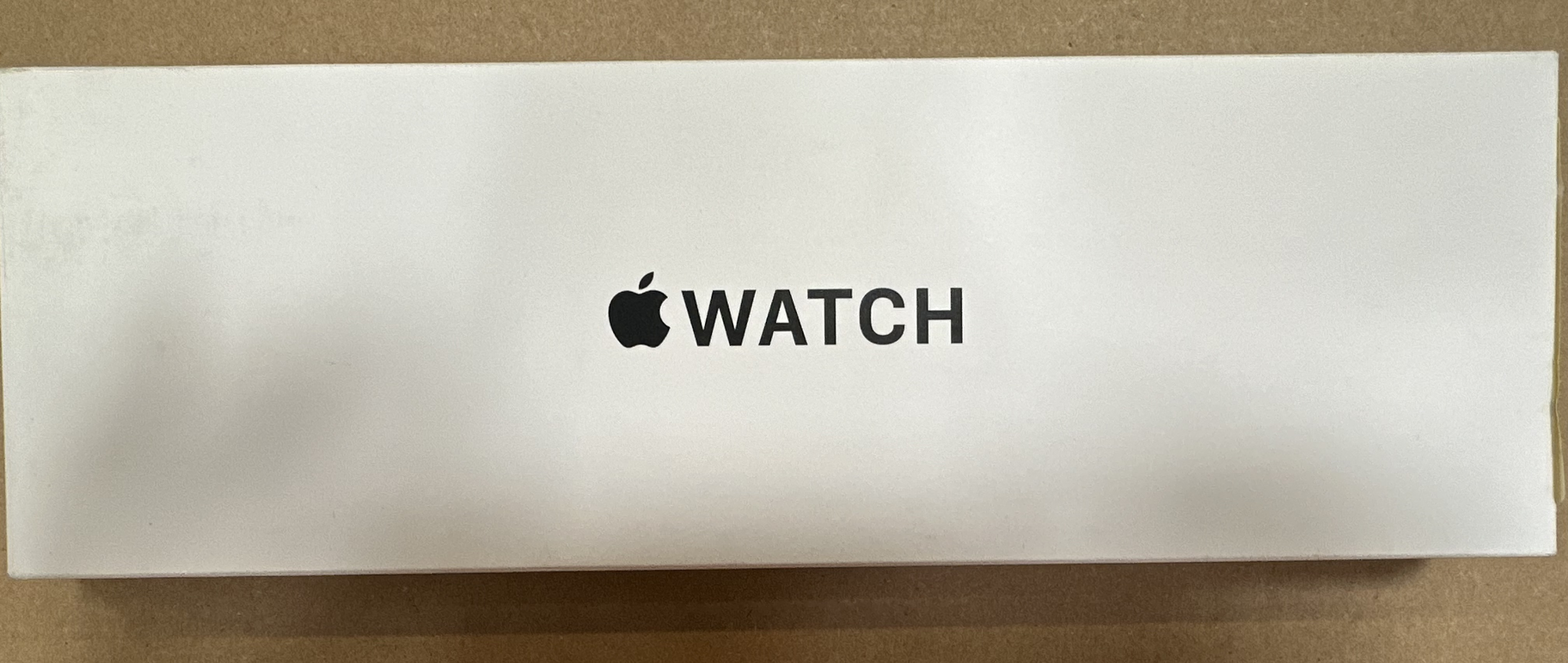 Białe pudełko Apple Watch z czarnym logo Apple i napisem WATCH.