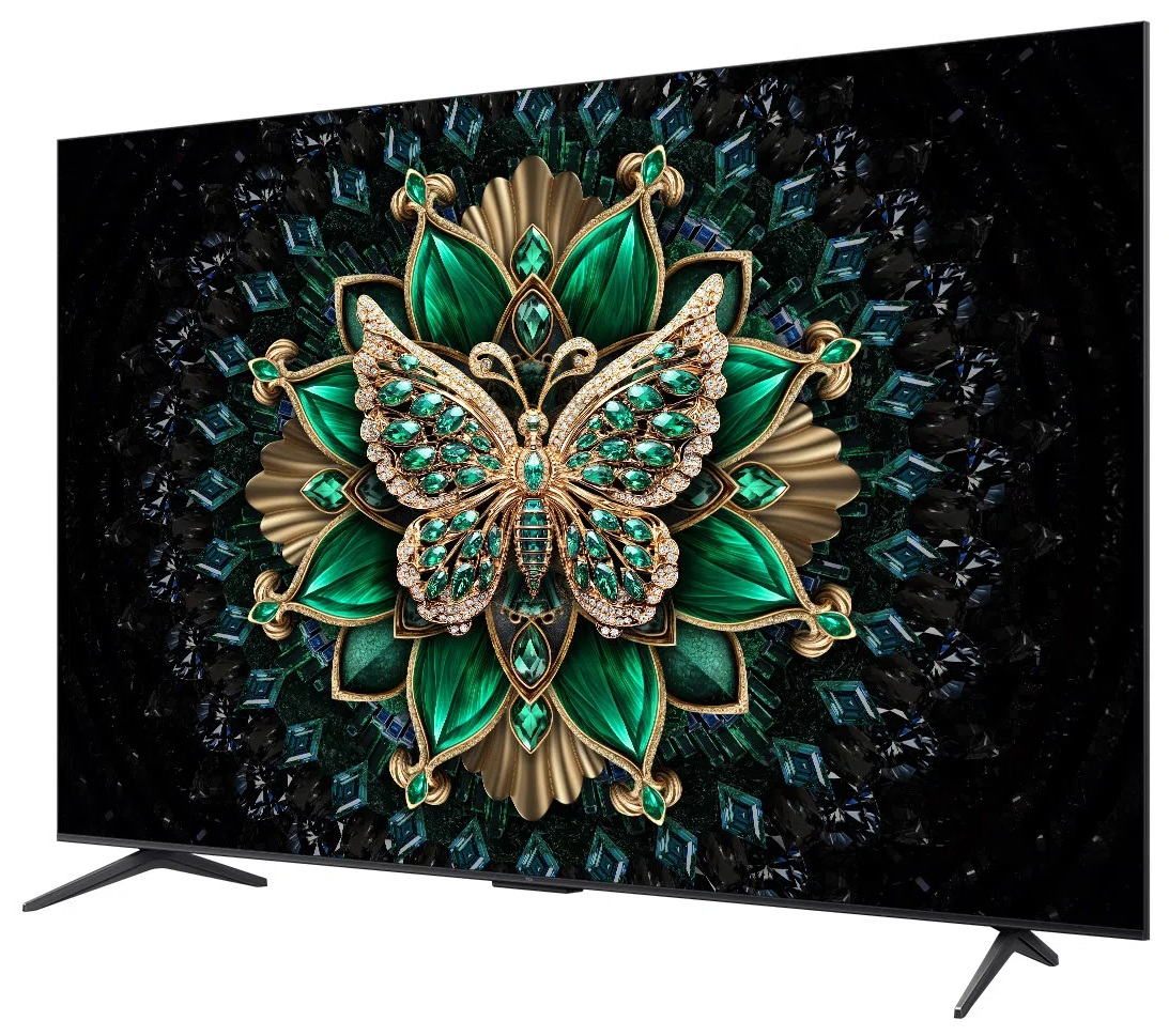 Ekran telewizora wyświetla motyla z zielonymi kamieniami i złotymi akcentami na czarnym, wzorzystym tle.