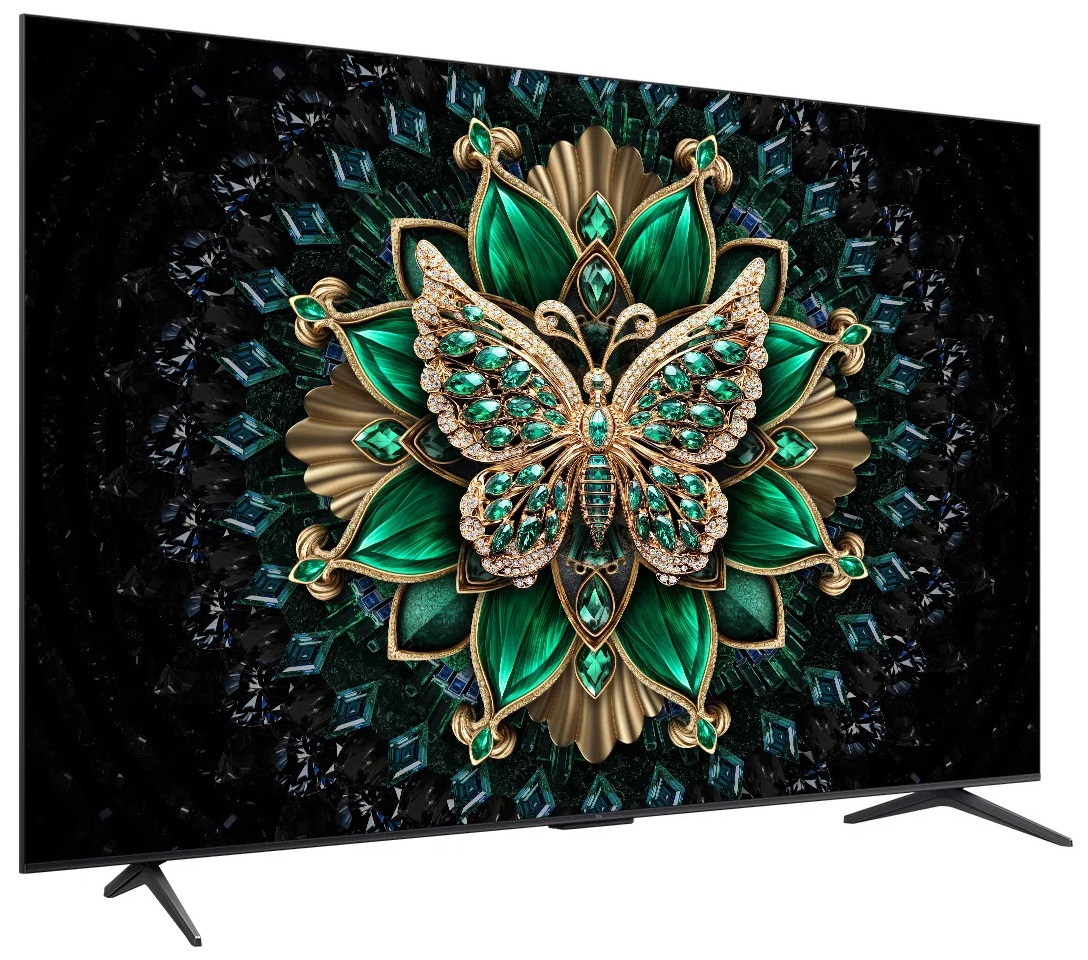 Ekran telewizora pokazuje wzór motyla z zielonymi kamieniami i złotem na czarnym, wzorzystym tle.