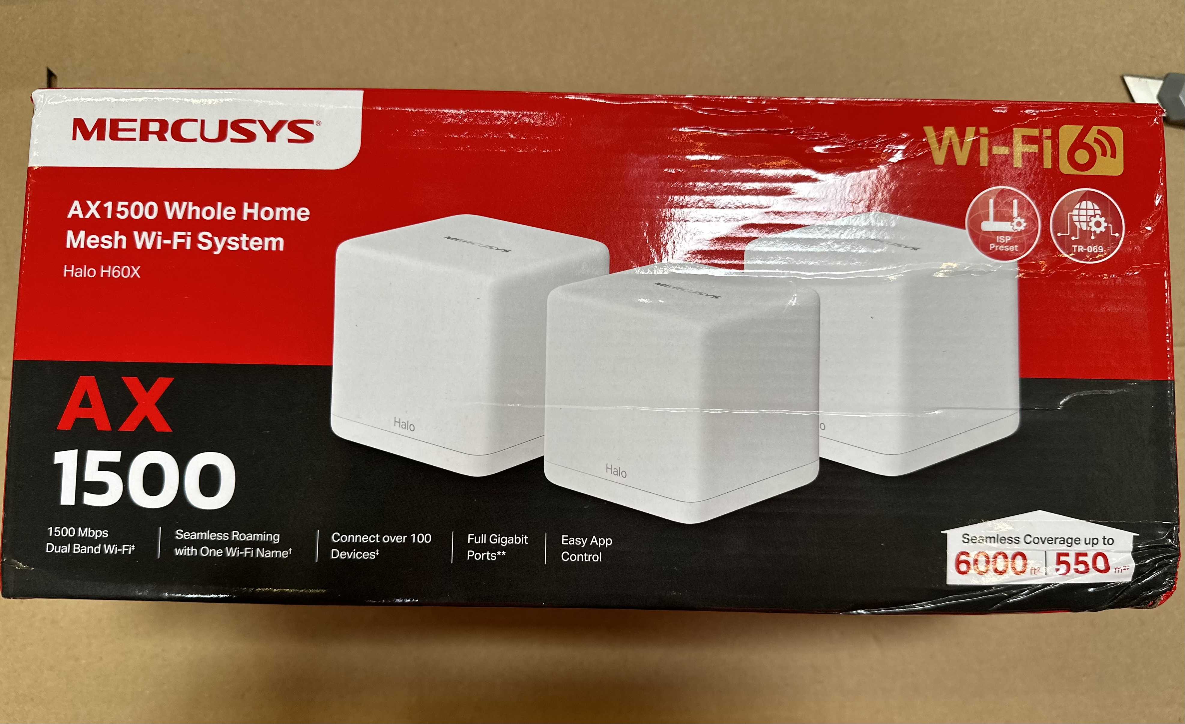Czerwono-białe pudełko z etykietą Mercusys. Zawiera trzy białe jednostki Wi-Fi mesh.