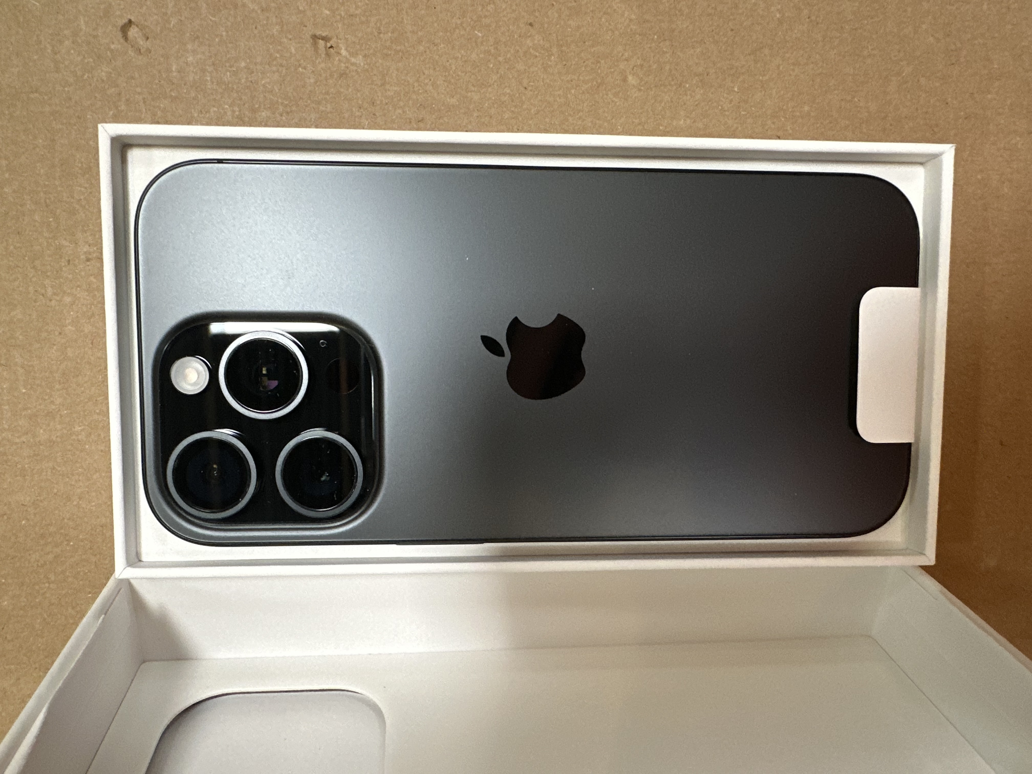 iPhone w pudełku. Widoczny tył telefonu z aparatami.