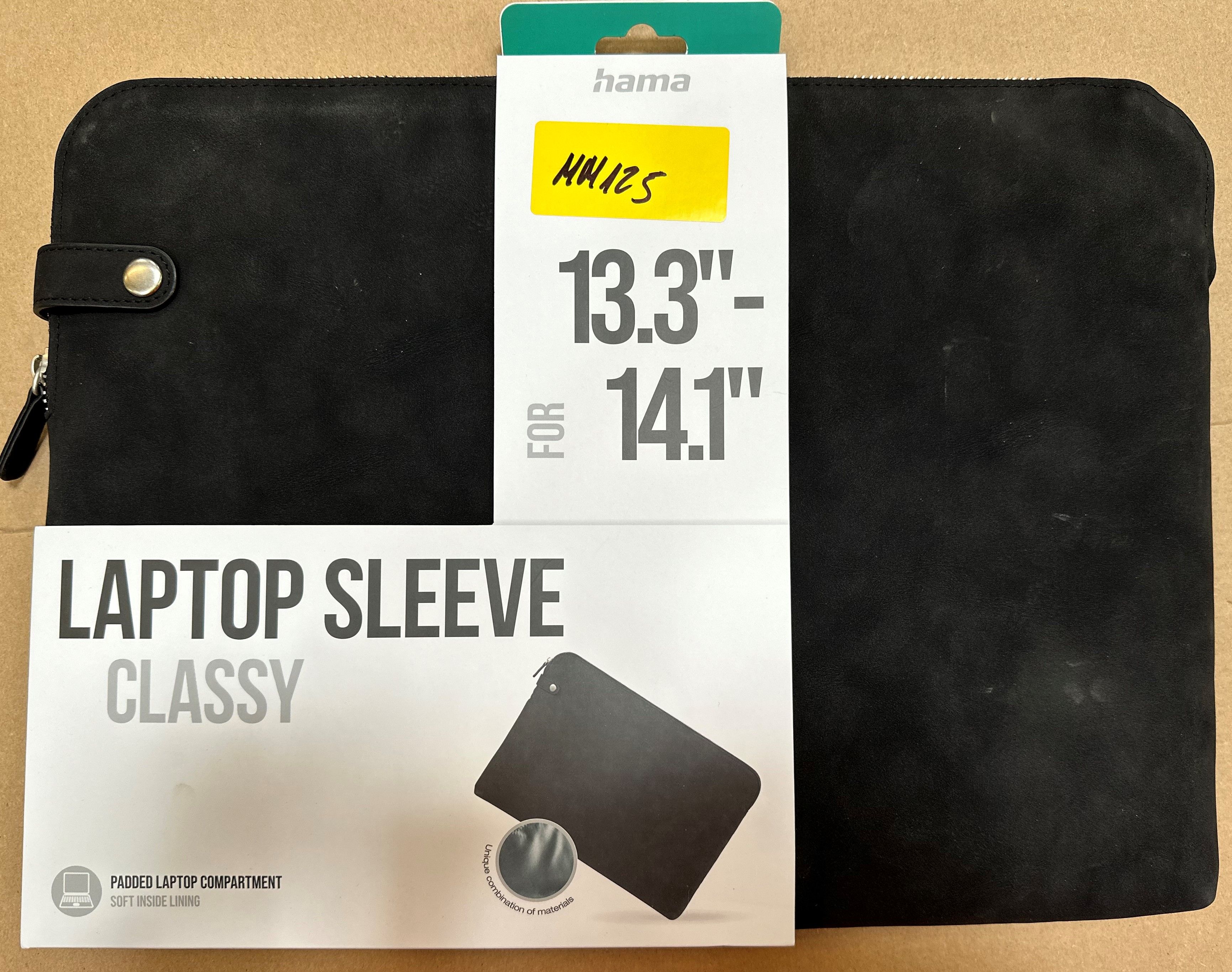 Etui na laptopa w opakowaniu. Czarna osłona i białe opakowanie. Tekst: LAPTOP SLEEVE CLASSY.