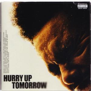 Nahaufnahme eines Gesichts auf einem Albumcover. Der Text 'HURRY UP TOMORROW' steht unten.