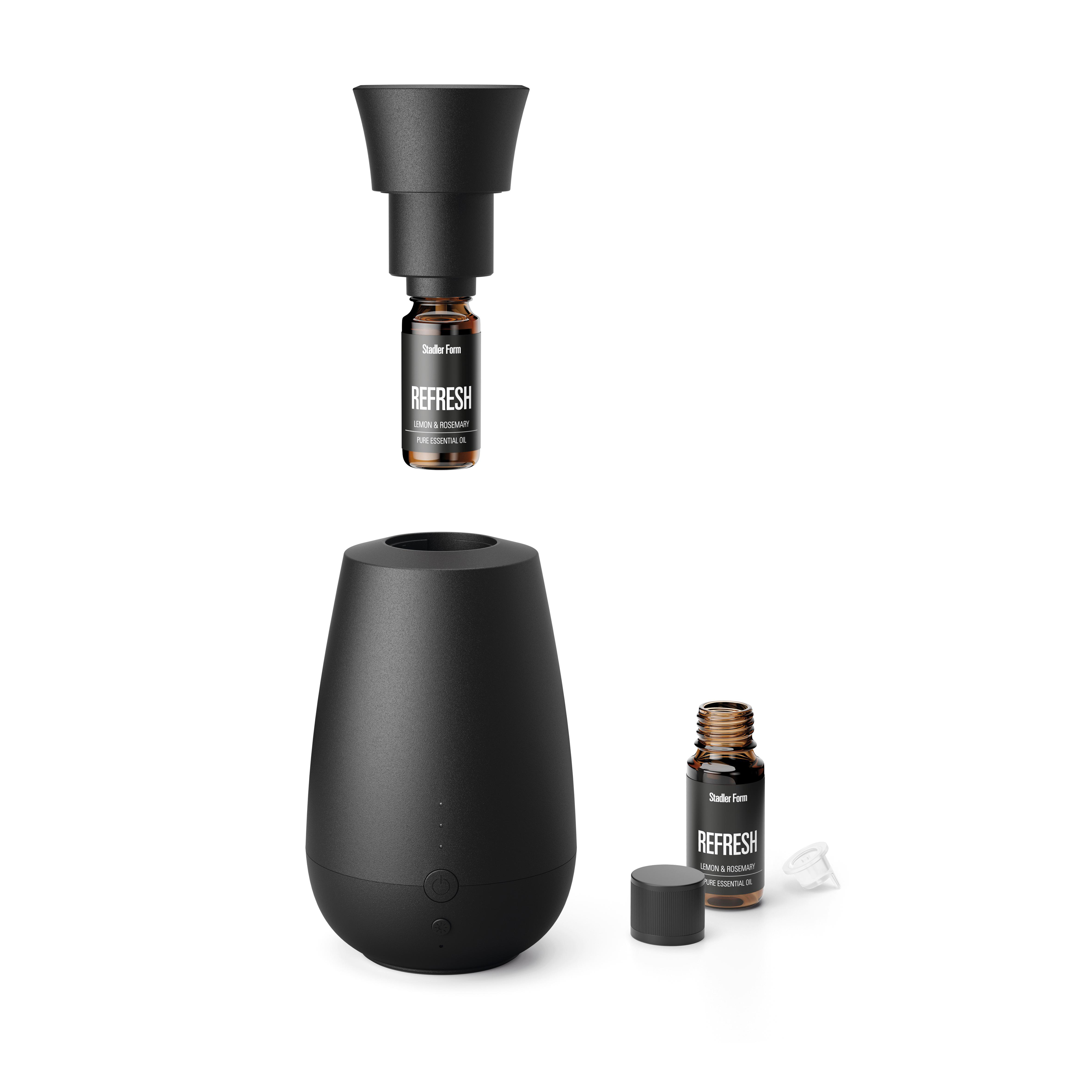 Schwarzer Aroma-Diffusor und ätherische Ölflaschen. Weißer Hintergrund. Produktaufbau.