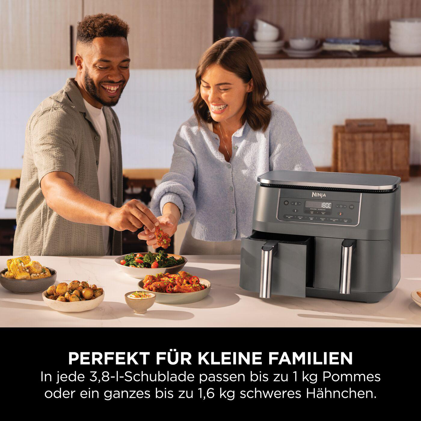 Leute sitzen an einem Tisch mit Essen und einer Ninja-Heißluftfritteuse.