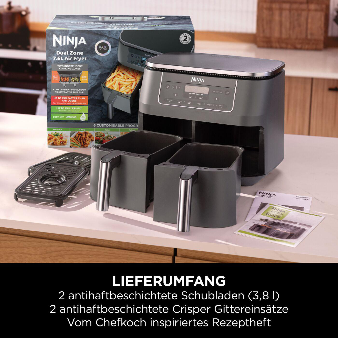 Eine Heißluftfritteuse mit herausnehmbaren Körben und Zubehör sowie Verpackung zur Ansicht.