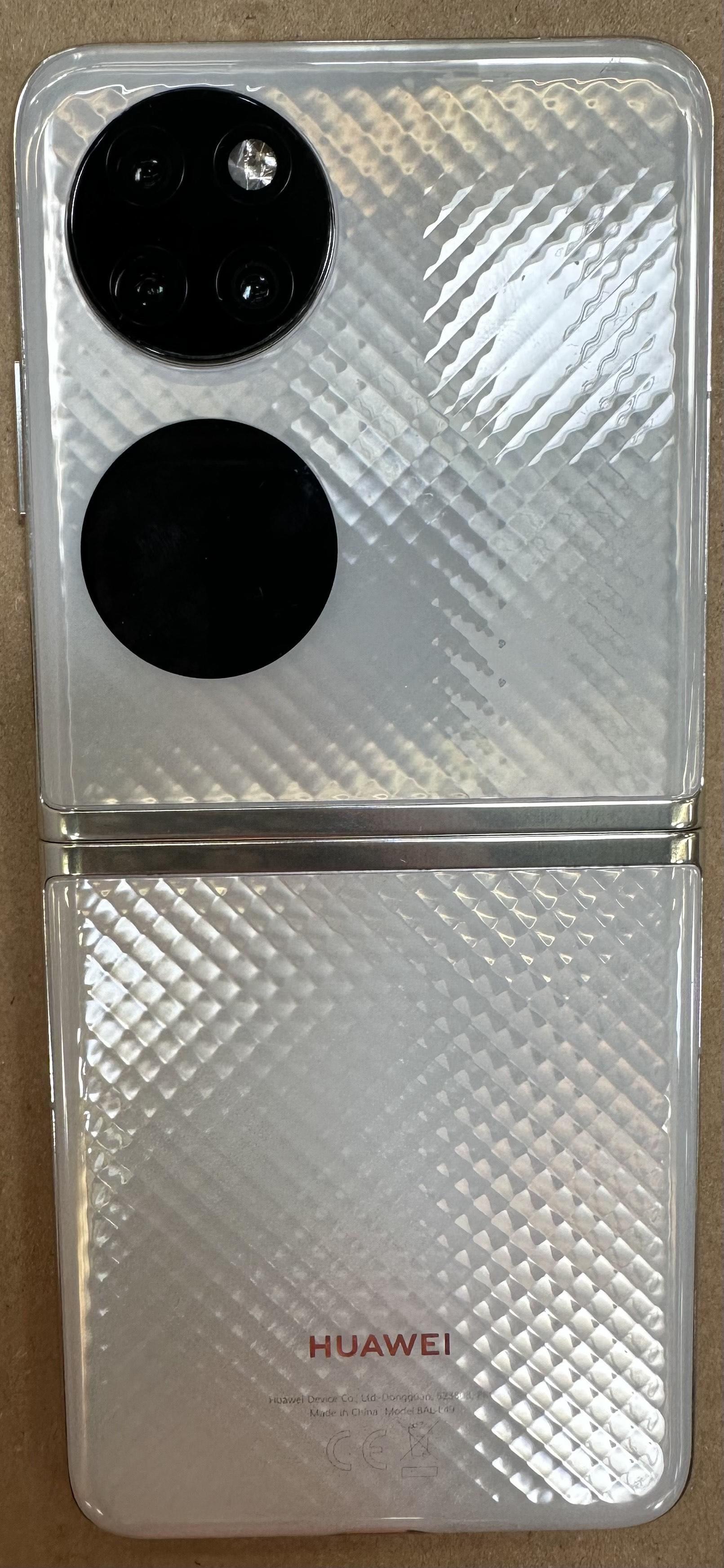 Biały telefon Huawei P50 Pocket, złożony. Tylne kamery i teksturowana obudowa.