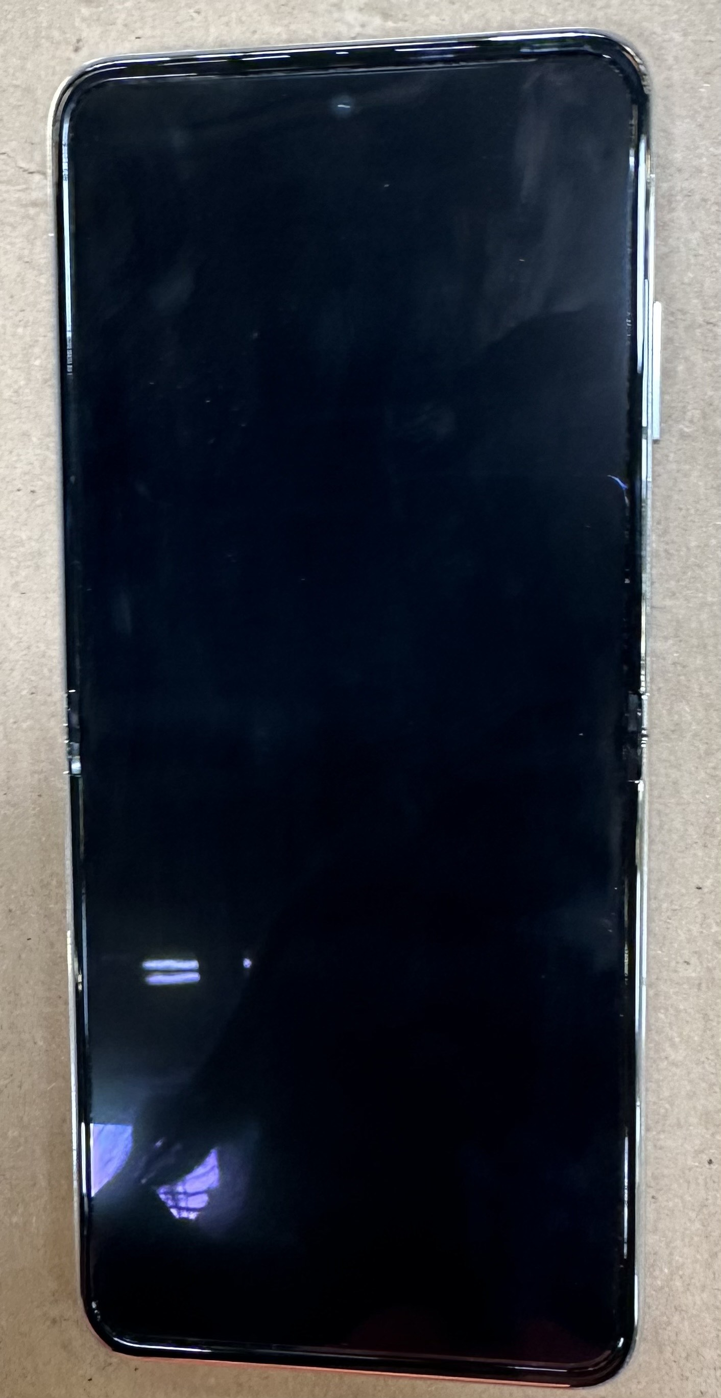 Telefon Huawei P50 Pocket, rozłożony. Czarny ekran i srebrna ramka.