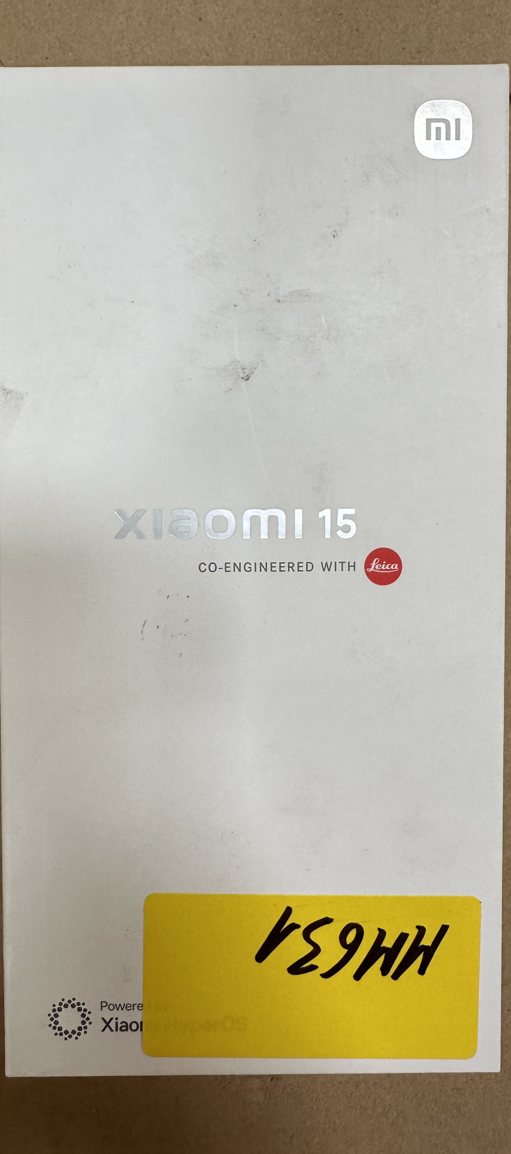 Białe pudełko z logo Xiaomi 15 i logo Leica z żółtą naklejką.