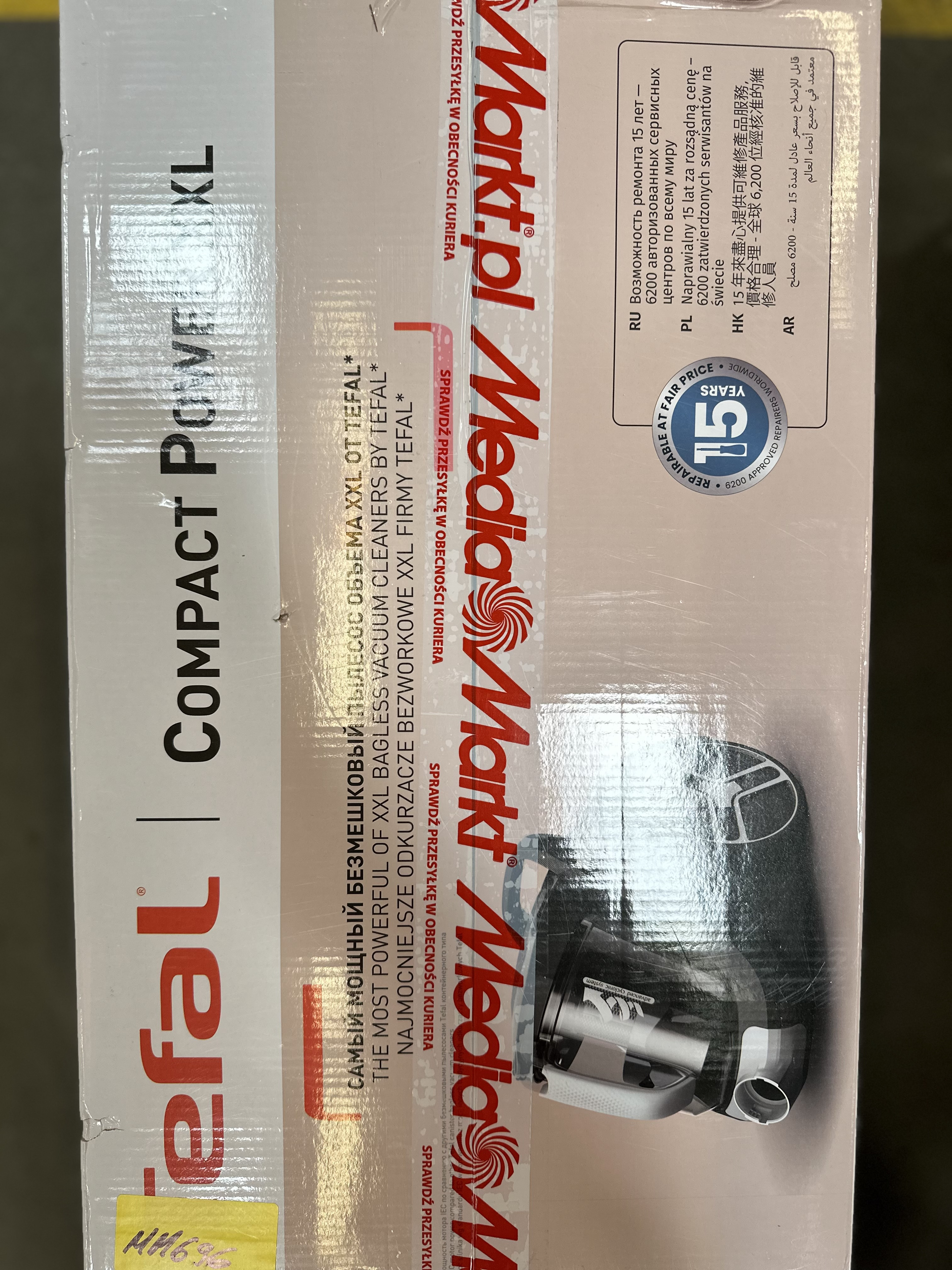 Pudełko od odkurzacza z tekstem w wielu językach. Marka to Tefal.