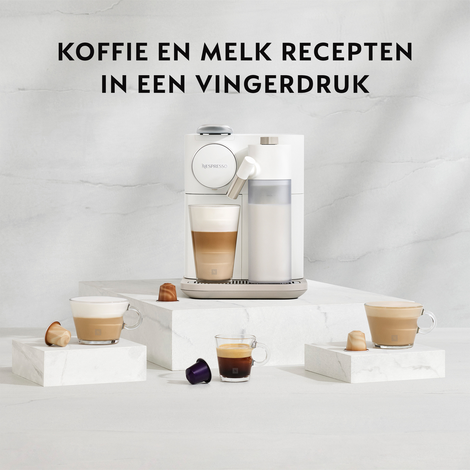 White coffee machine with coffee cups on marble blocks and capsules.
