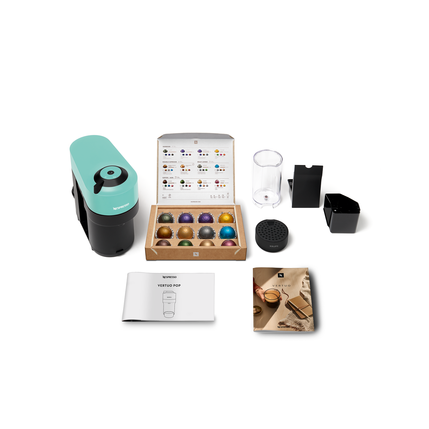 Nespresso Vertuo Pop machine and accessories: pods box, cup, water container, and other items.