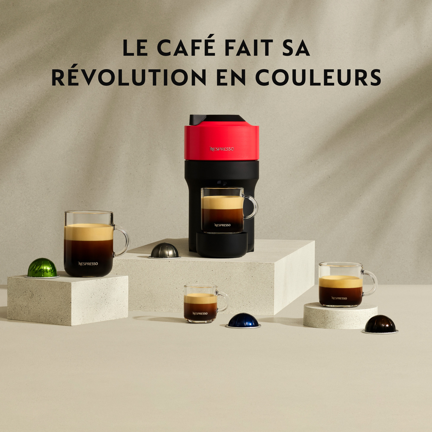 Machine à café avec tasses et capsules. Rouge et noir. Superposition de texte.