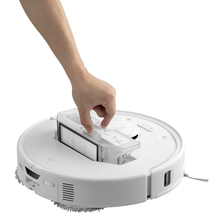 Eine Hand legt einen Filter in einen weißen Roborock-Staubsauger. Der Staubsauger ist rund.