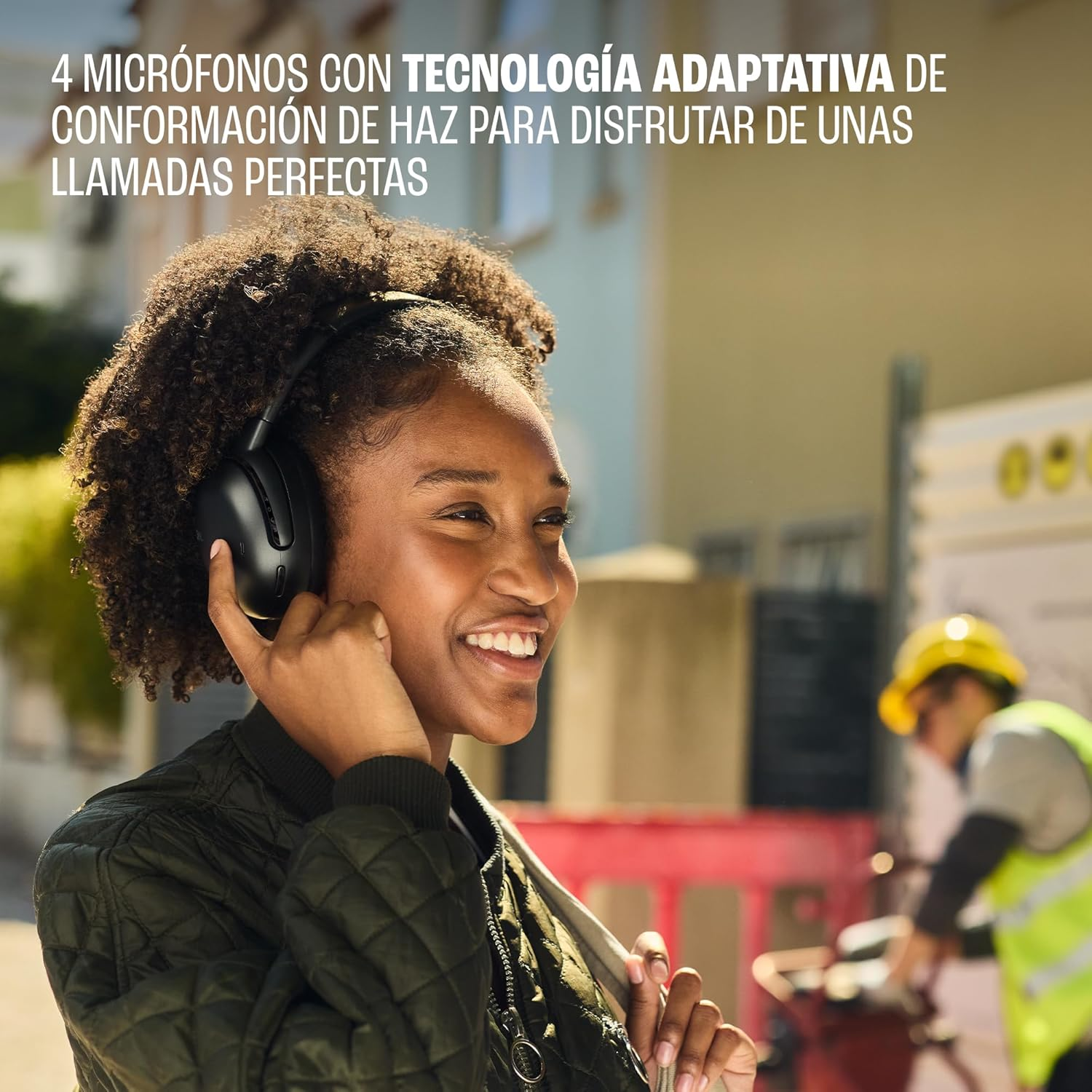 Mujer con auriculares negros sonríe afuera.