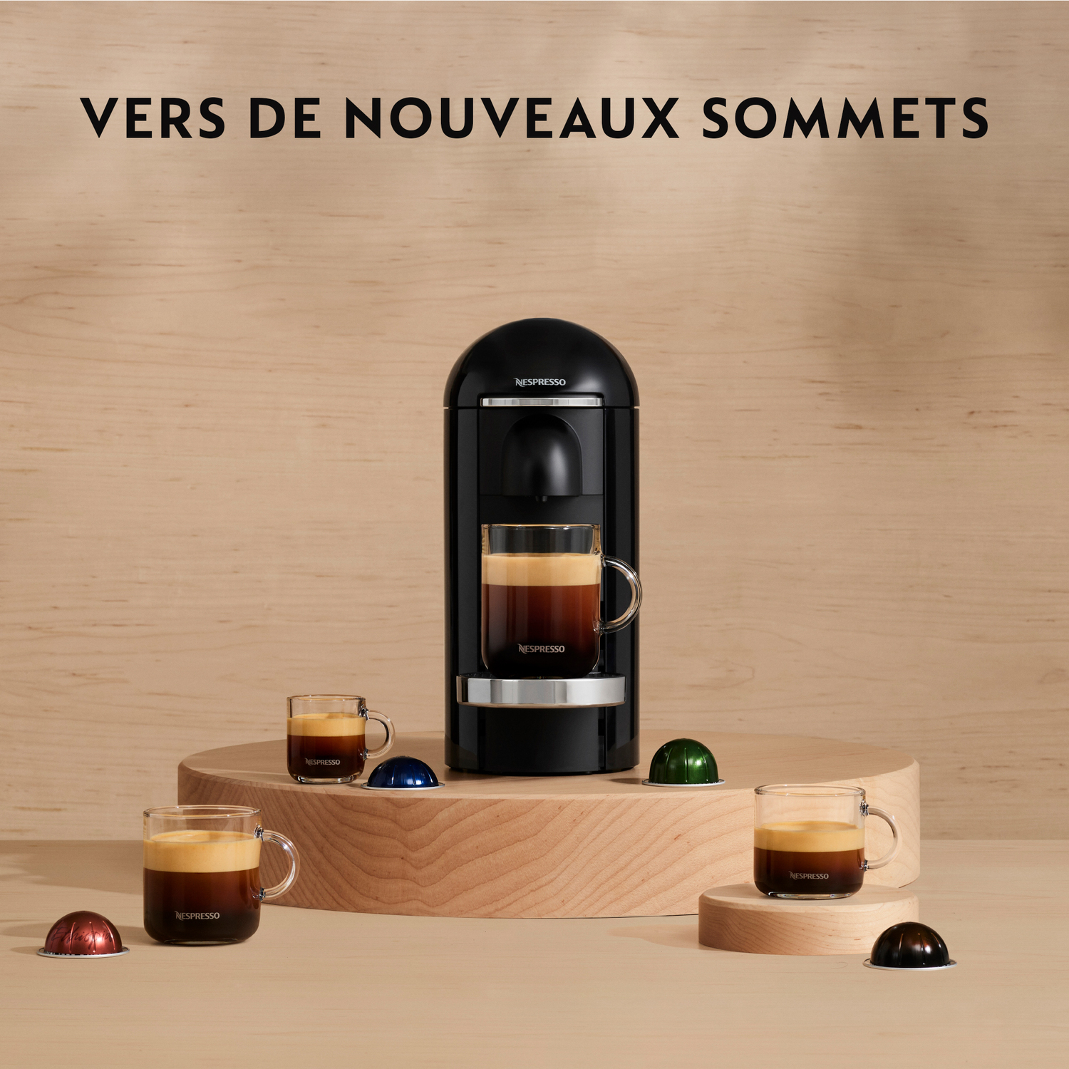 Une machine Nespresso avec tasses et capsules sur une table. Montrant une variété de cafés.