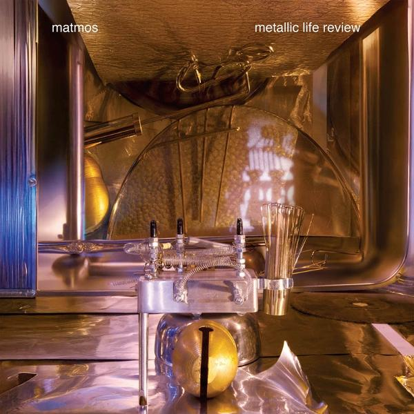 Ein metallischer Gegenstand mit verschiedenen Teilen und einer goldenen Kugel. Text: matmos, metallic life review.