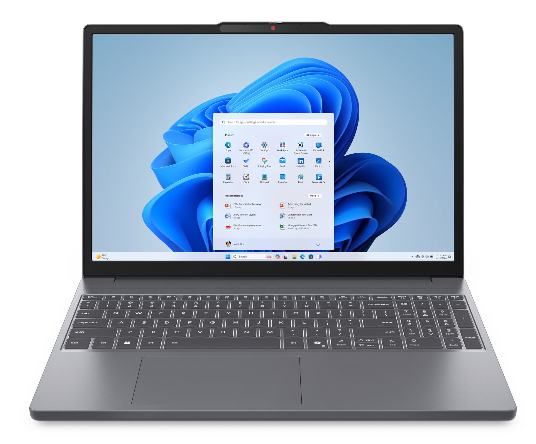 Laptop na czarnej powierzchni. Ekran pokazuje menu start Windows.