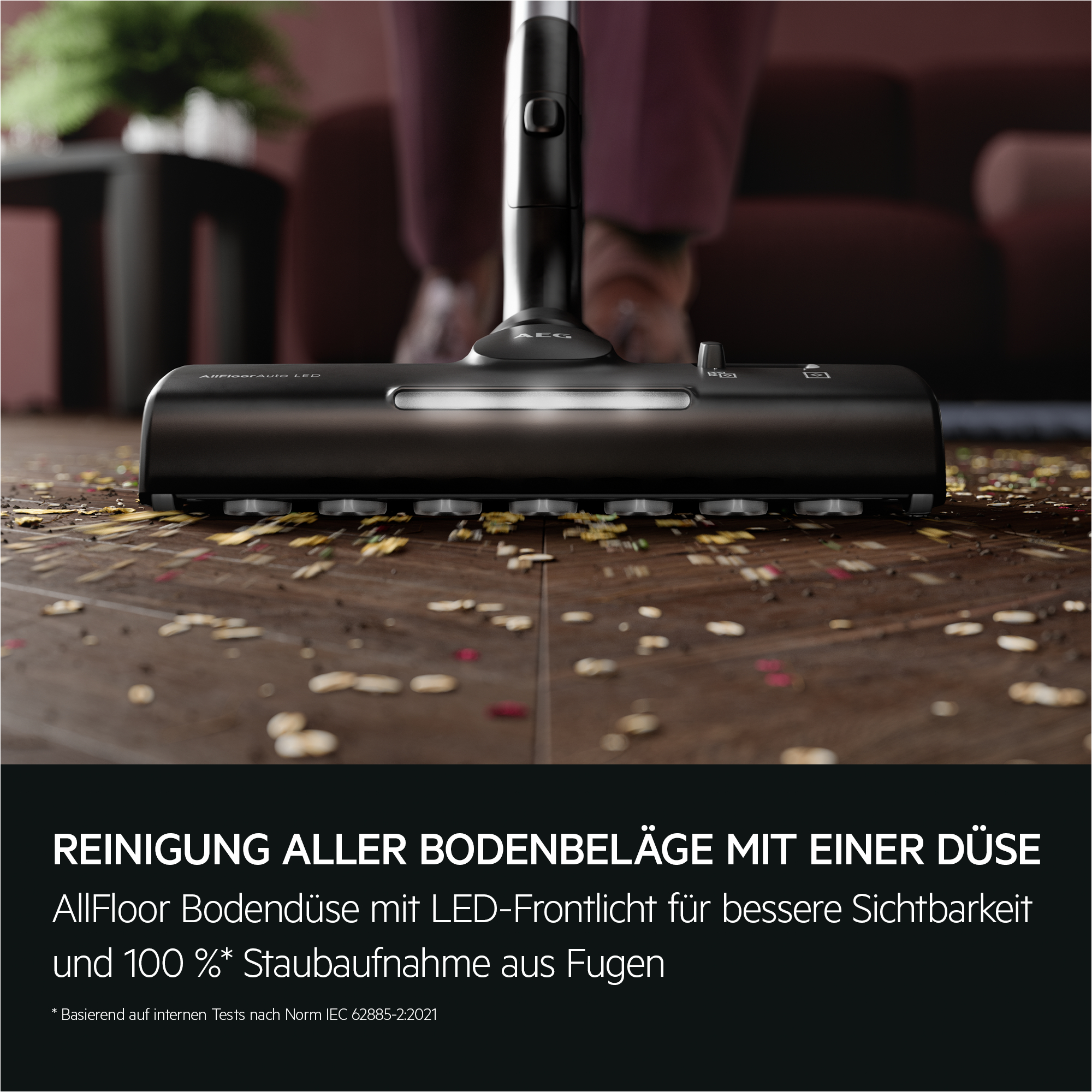 Staubsaugerkopf auf Holzboden, umgeben von Schmutz.