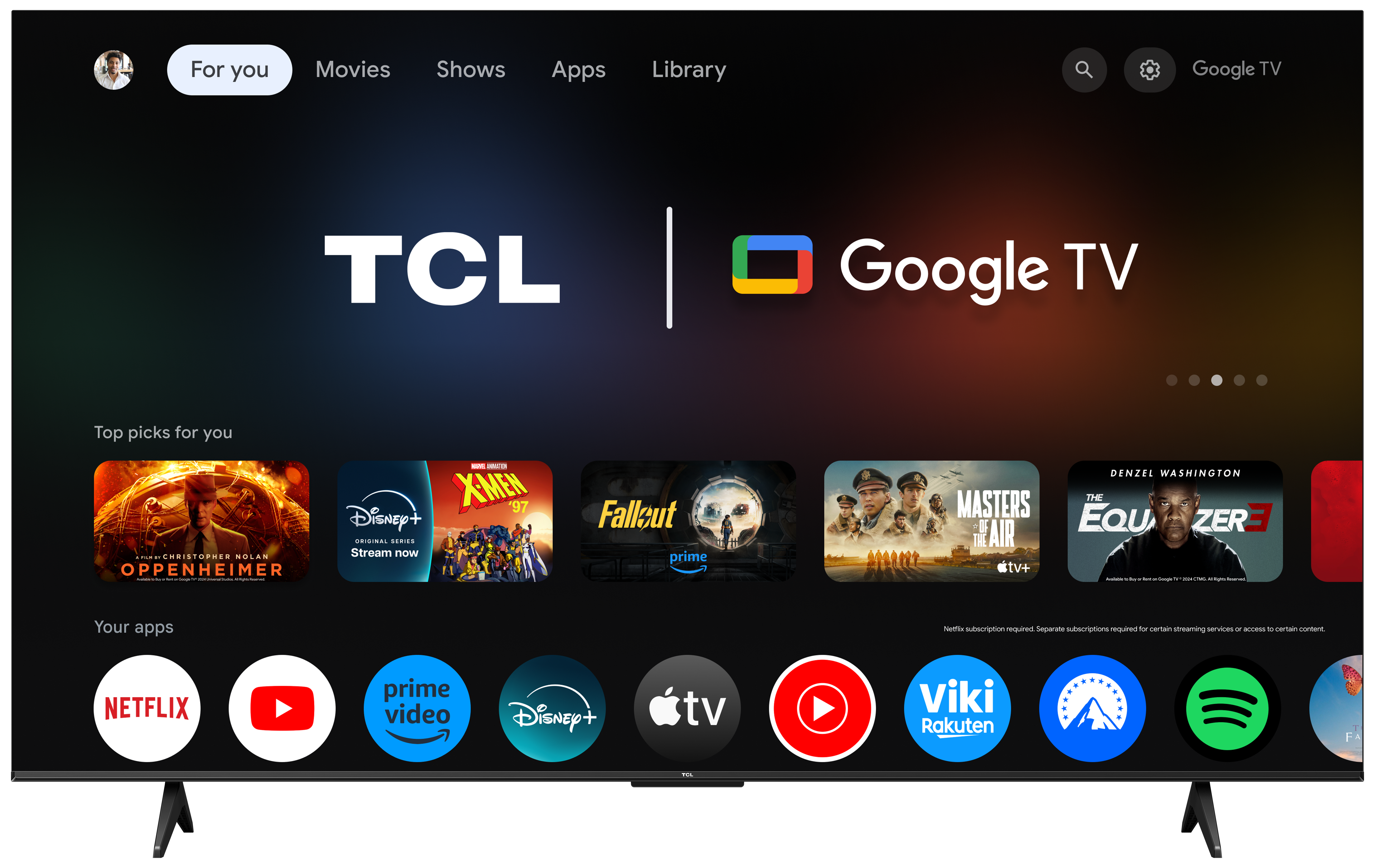 TCL Google TV włączony, pokazujący ekran główny. Wyświetla filmy, programy, aplikacje i pasek wyszukiwania. Czarna ramka.