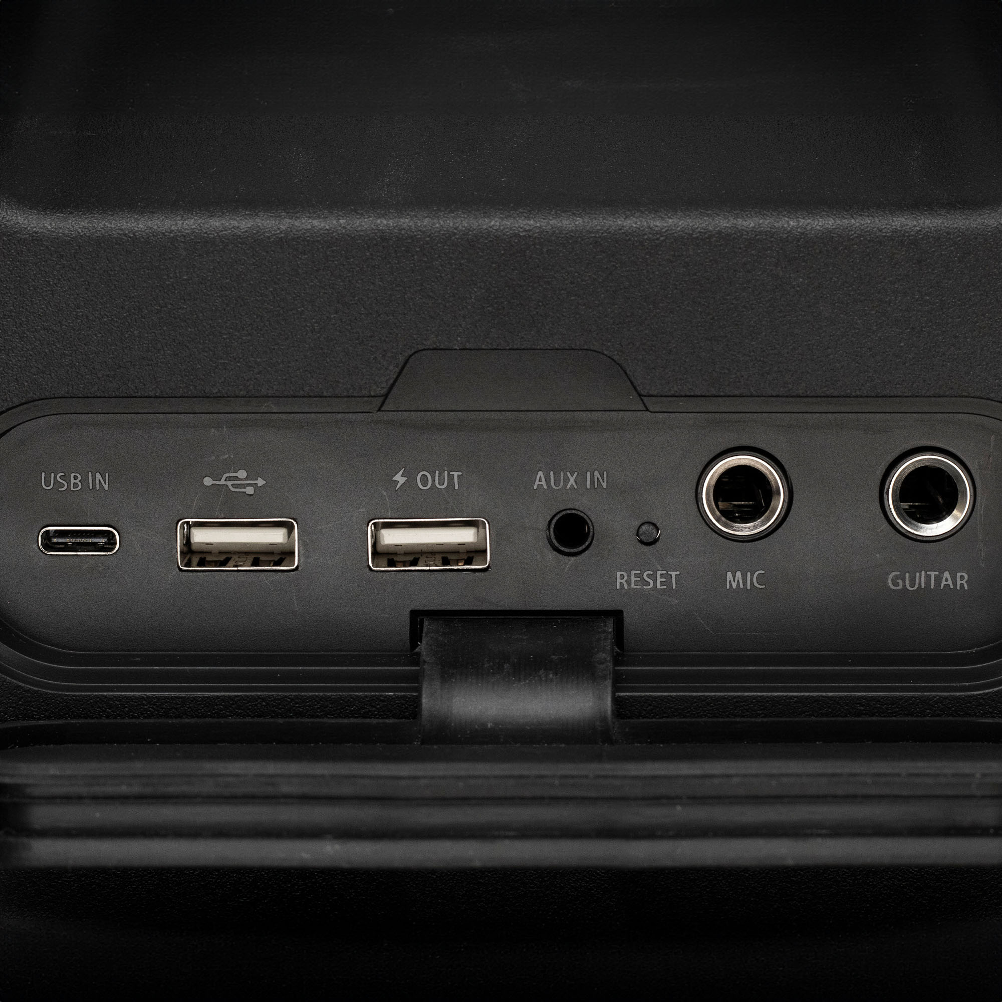 Közelkép egy fekete hangszóró csatlakozóiról: USB, AUX, MIC és GUITAR.
