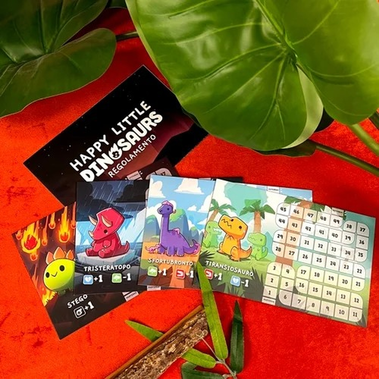 Carte di gioco da tavolo e una foglia. Le carte raffigurano dinosauri.