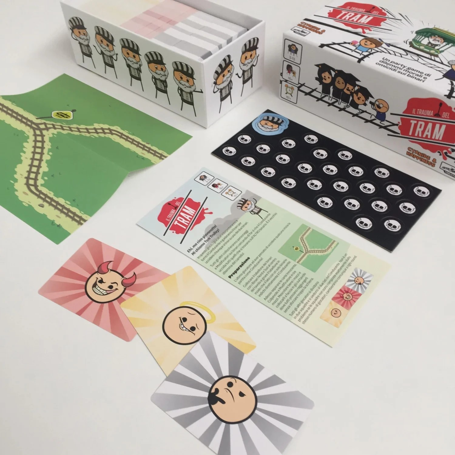 Componenti di gioco, tra cui carte con facce di cartoni animati e una scatola con figure di cartoni animati.