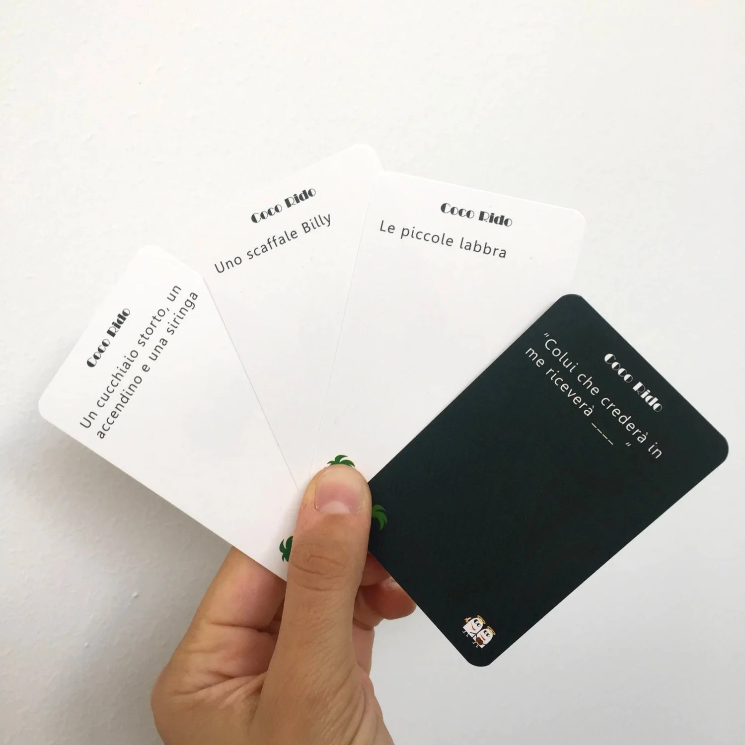 Mano che tiene carte da gioco con testo, con una carta da gioco con logo.
