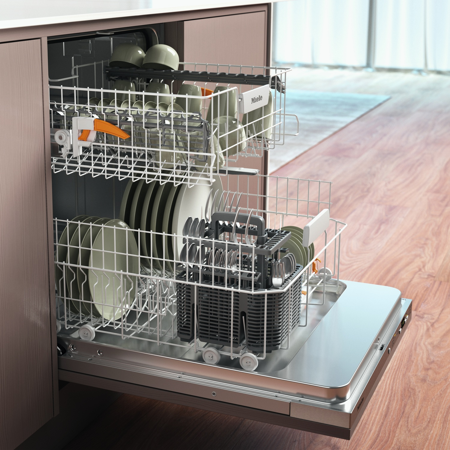 Interno di una lavastoviglie Miele con piatti, bicchieri e utensili. Porta aperta.
