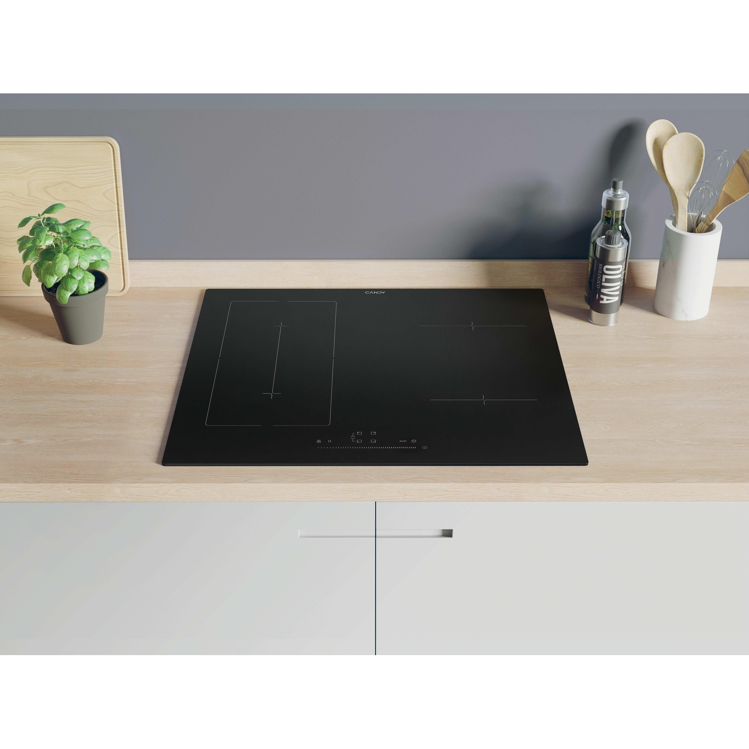 Piano cottura a induzione Candy nero su superficie in legno. Scena cucina con piante e utensili.
