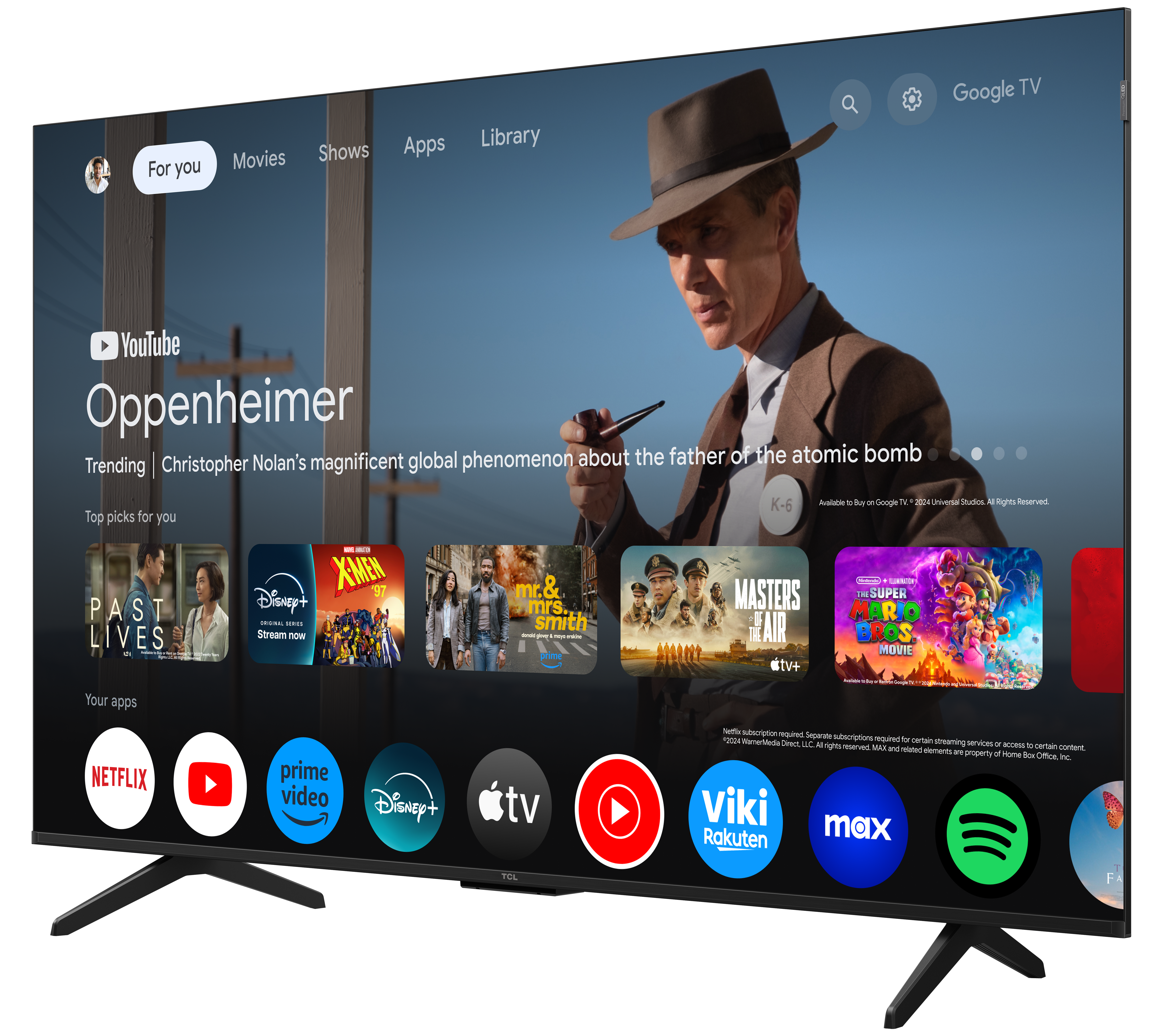 Telewizor TCL z interfejsem Google TV, z plakatem filmowym i ikonami aplikacji.