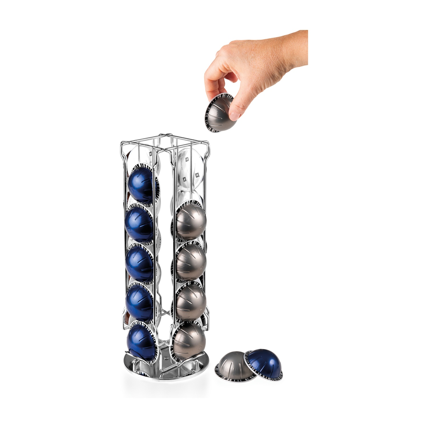 Porta capsule per caffè argentato con capsule blu e grigie. Una mano prende una capsula.