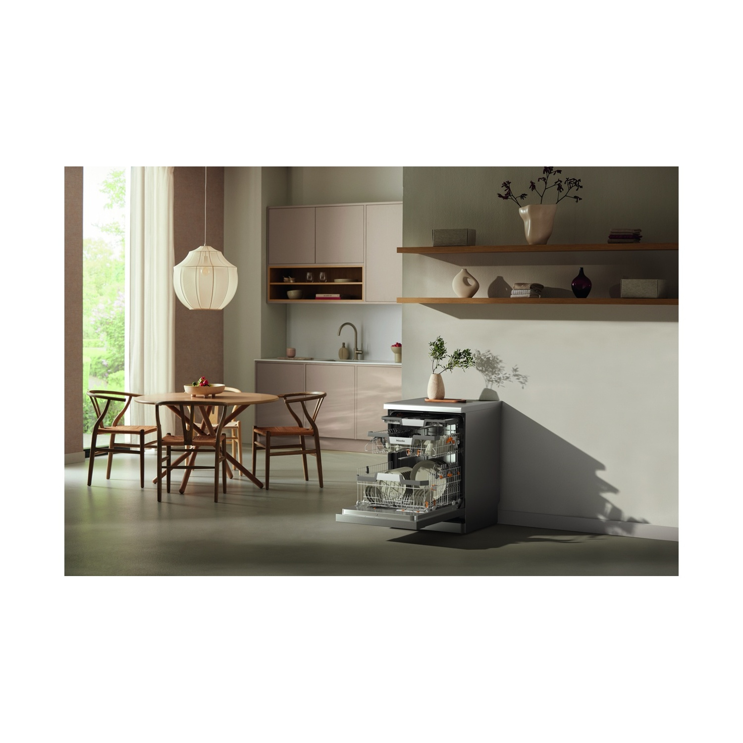 Scena cucina con lavastoviglie aperta. Tavolo rotondo in legno e sedie. Interior design.