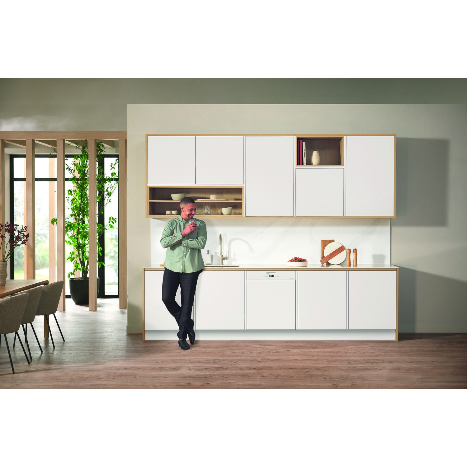 Scena cucina con lavastoviglie aperta e un uomo in piedi accanto. Design moderno.