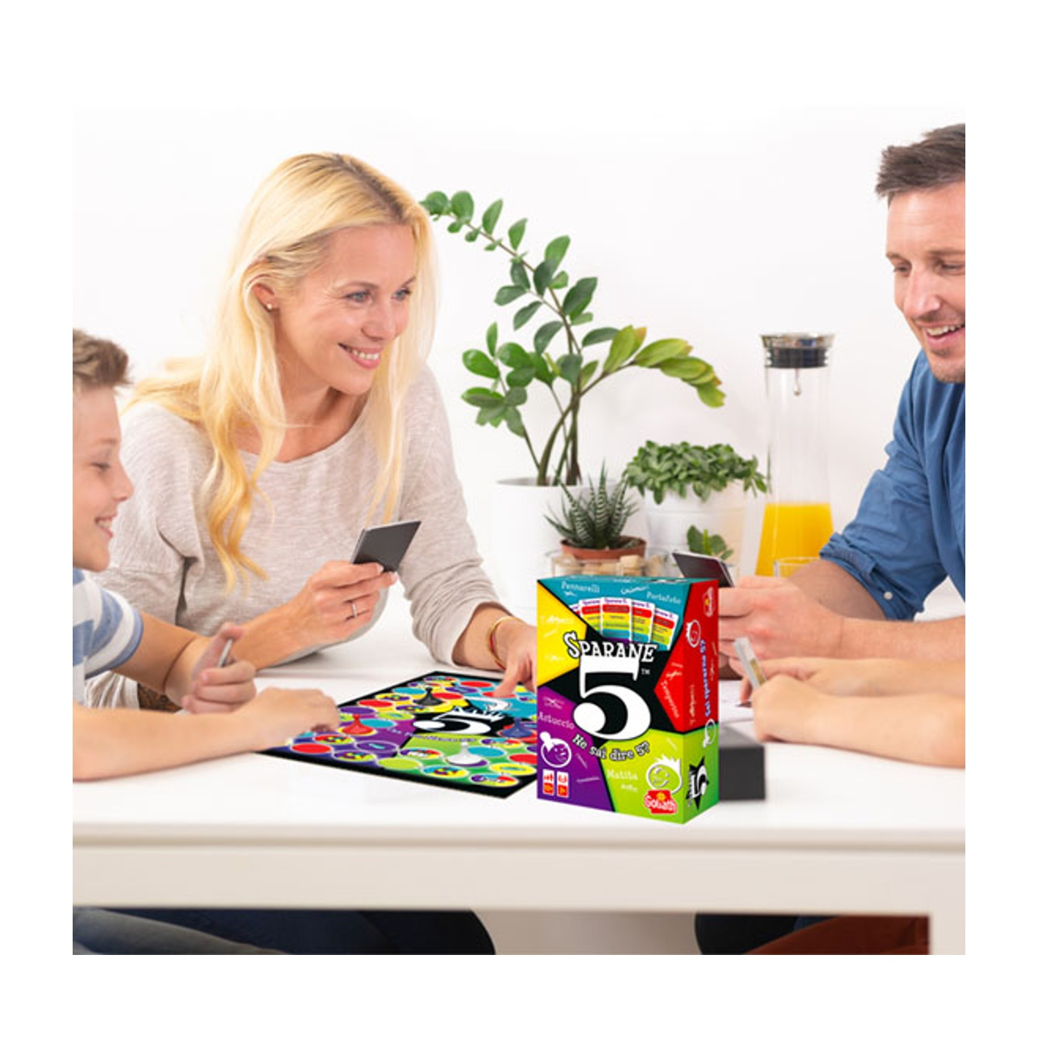 Una famiglia che gioca al gioco di carte 'Sparane 5?' a tavola.