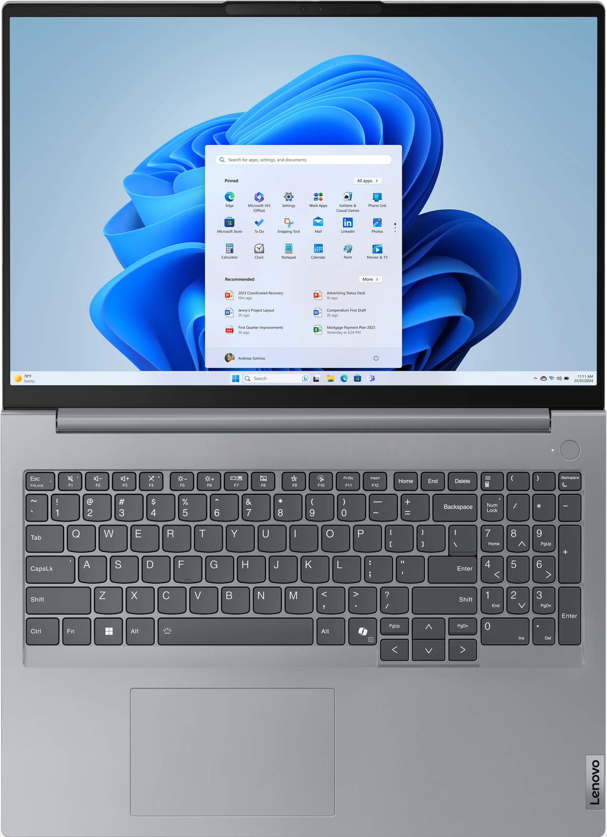 Draufsicht auf einen Lenovo-Laptop, der Tastatur, Trackpad und Bildschirm mit Windows 11-Oberfläche zeigt.