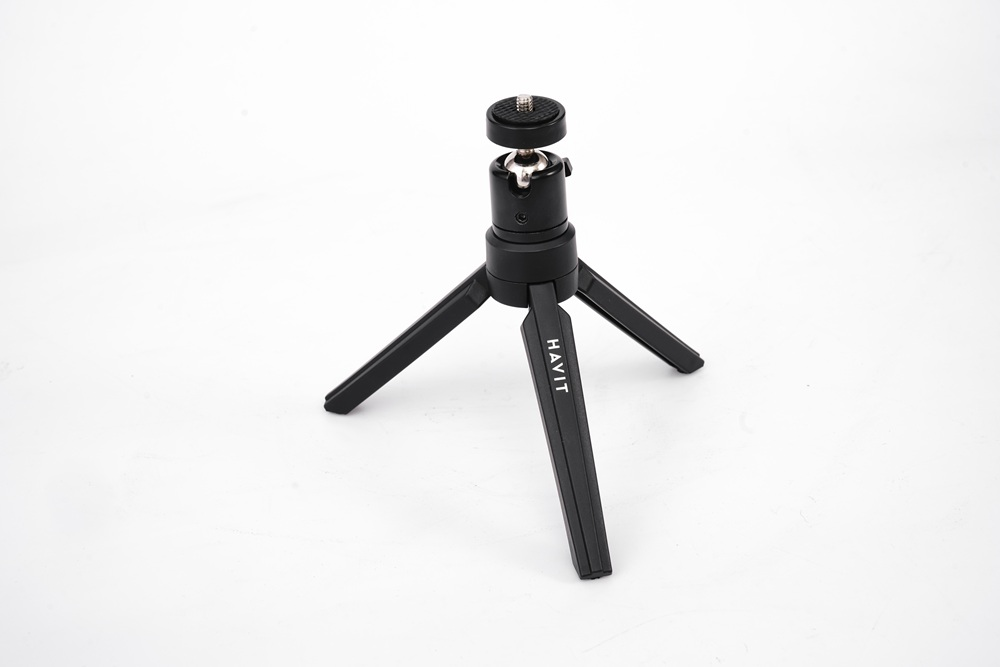 Siyah mini tripod. HAVIT metni. Ayarlanabilir kafalı üç bacak.