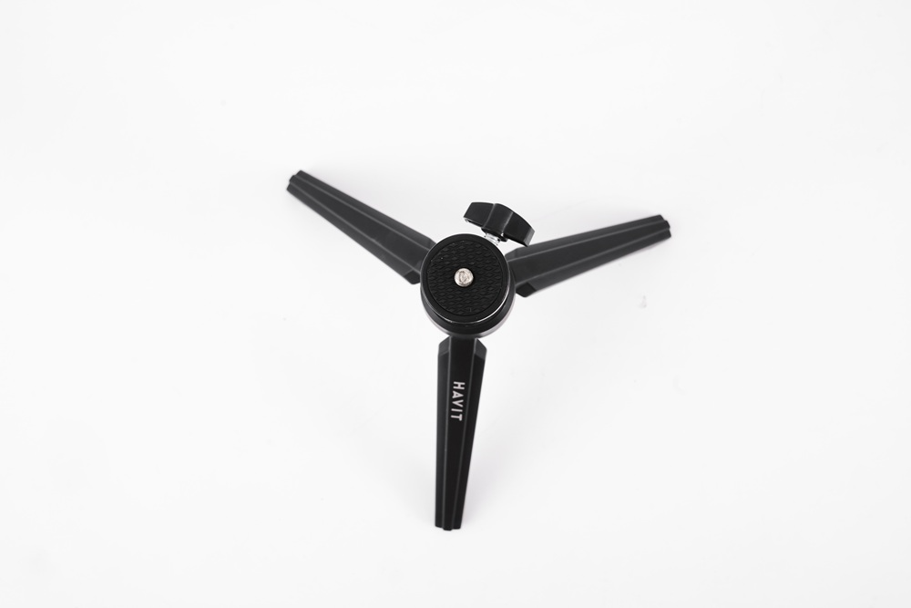 Siyah mini tripod bacakları. HAVIT metni. Üç bacak, beyaz arka plan.