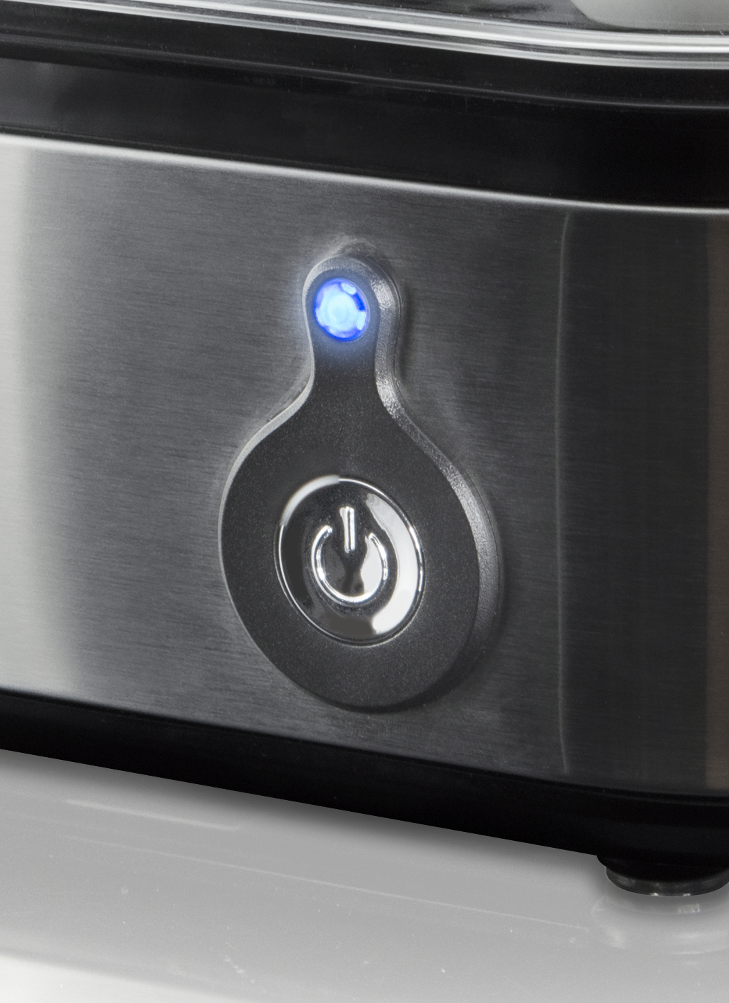 Nahaufnahme des Ein-/Aus-Knopfes des Koenic Eierkochers mit blauem Licht.